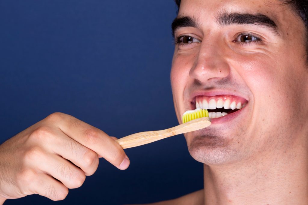 hombre joven cepillando sus dientes