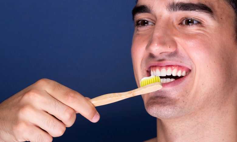 hombre joven cepillando sus dientes