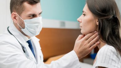Médico revisando garganta de paciente por cáncer