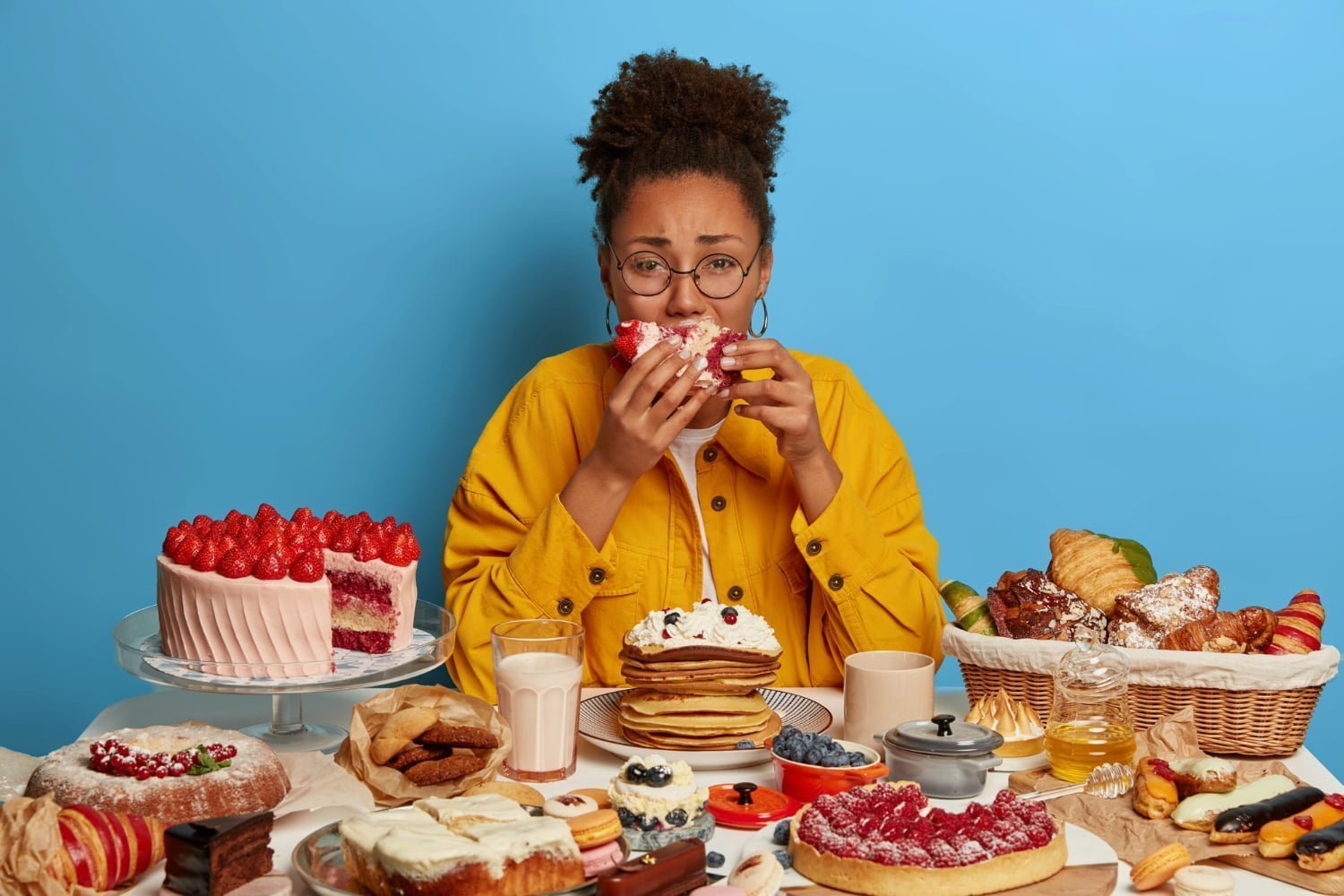 mujer comiendo en exceso por hambre emocional / desayuno / sobrepeso / antojos de azúcar antes de tu período