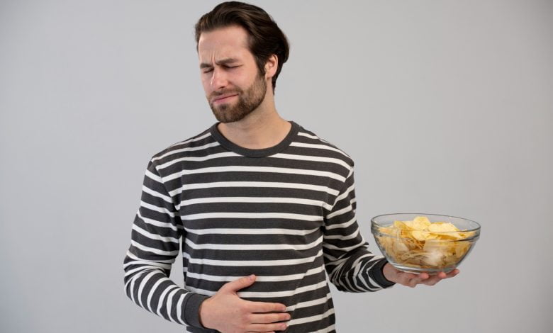 Hombre tocando su barriga por malestar de indigestión por comida. / intoxicación alimentaria
