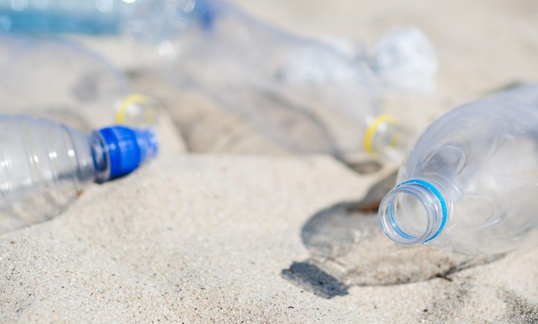 primer plano de la botella de agua plástica inútil vacía en la arena