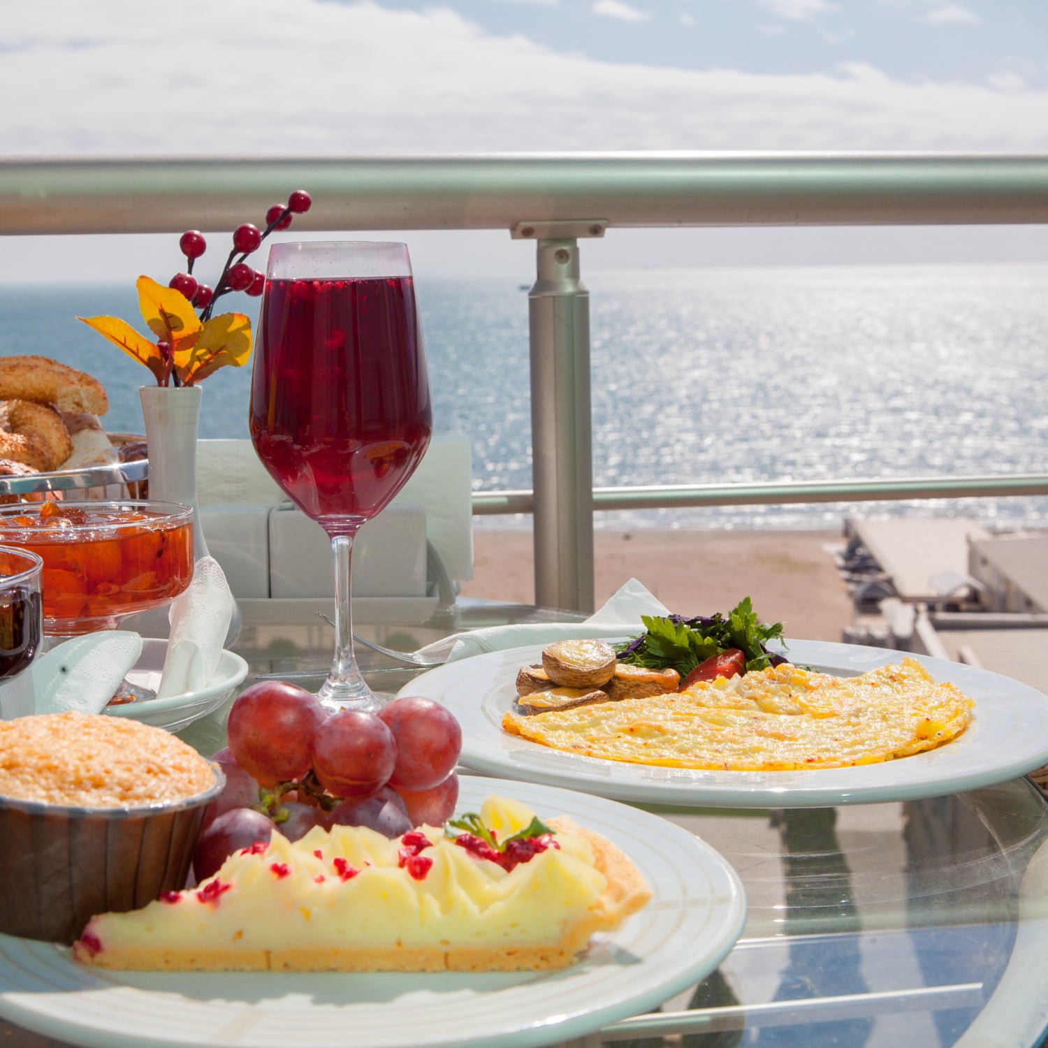 desayuno con horneado y uva y tortilla en plato blanco en el balcón junto al mar / crucero